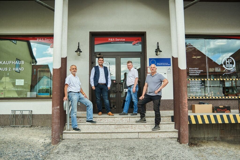 Vier Maenner vor dem Sozialkaufhaus H2HIBU in Hildburghausen